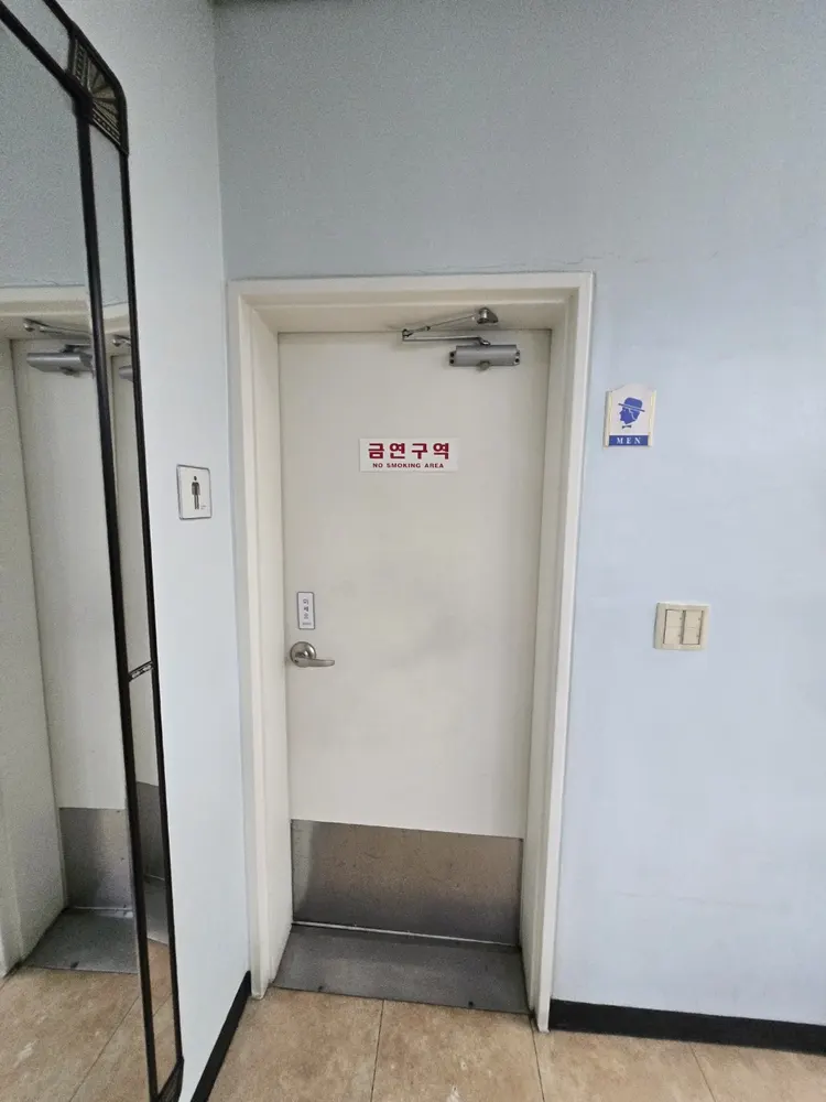 현관문 문틀 고정 부위를 재조정하는 작업 장면