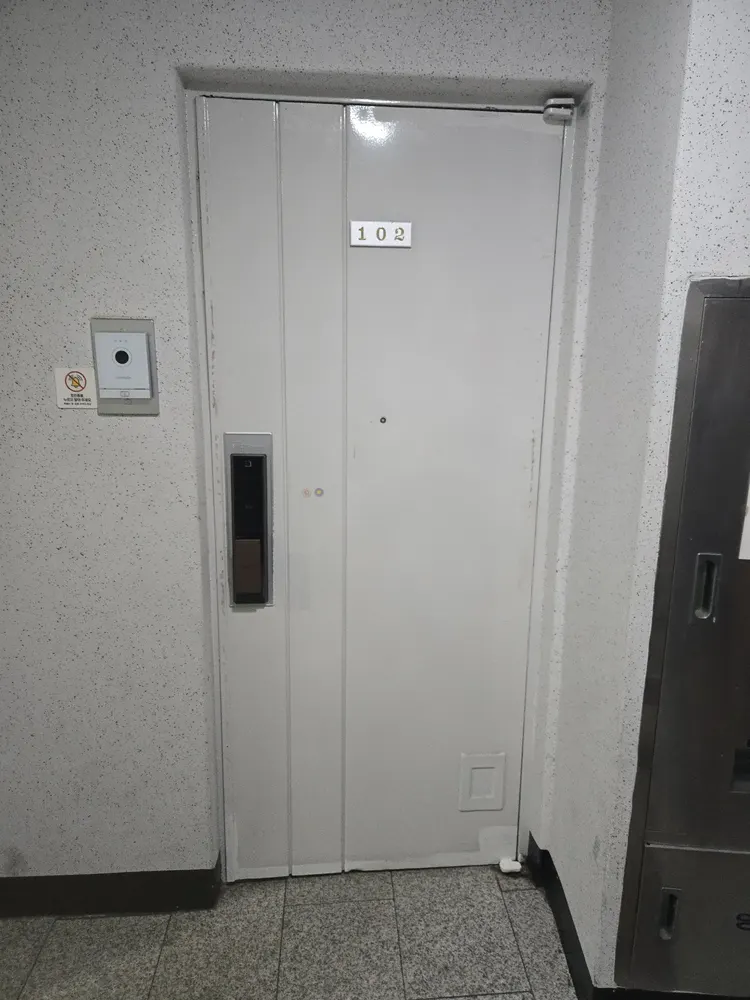 현관문 힌지 교체 시기를 판단하기 위해 마모 상태를 점검하는 모습